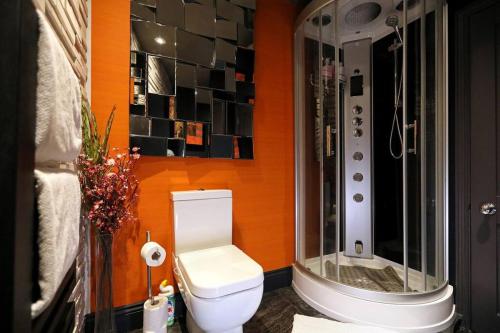 a bathroom with a toilet and a glass shower at Elegant Norwich Apartment in The Lanes w Parking in Norwich