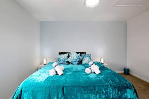 una camera da letto con un grande letto blu con cuscini di Stafford Rest Ginger & Gold Ltd a Norwich