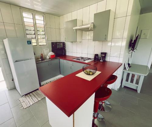 a kitchen with a red counter top and a refrigerator at KIANI HOME in Afaahiti