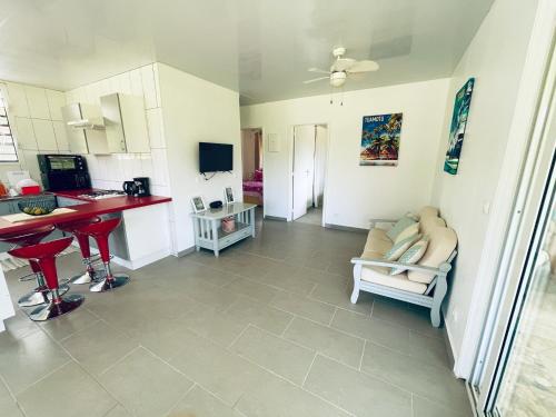 eine Küche und ein Wohnzimmer mit einem Tisch und einem Sofa in der Unterkunft KIANI HOME in Afaahiti