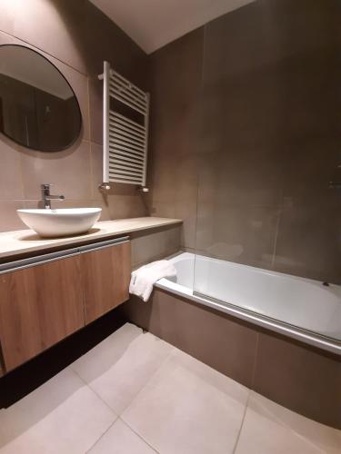 een badkamer met een wastafel en een ligbad bij Departamentos DSM in Necochea