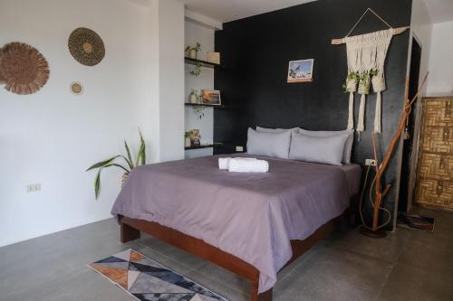 盧納將軍城的住宿－Happiness Beach Resort Siargao，一间卧室配有一张黑色墙壁的床