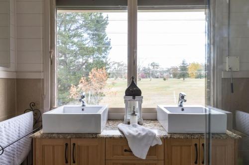 a bathroom with two sinks and a large window at Stonelinks House sleeping 12 in Leura