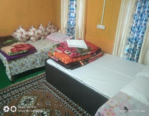 two beds sitting next to each other in a room at Chiten Homestay by StayApart in Sonāda