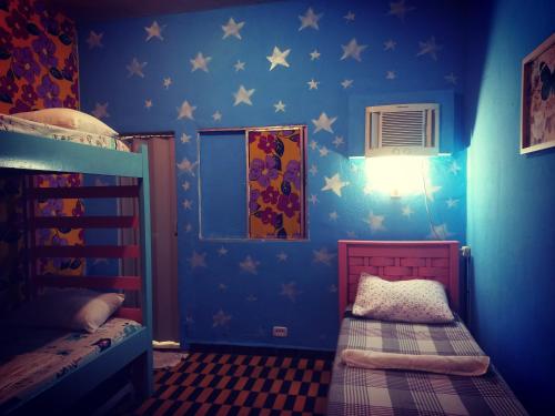 Hostel & Pousada UFPE INN في ريسيفي: غرفة زرقاء مع سريرين بطابقين فيها