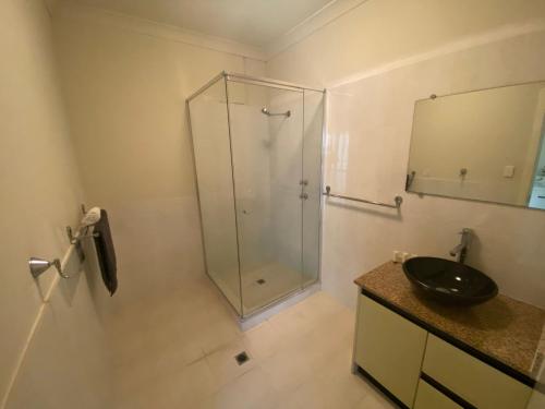 a bathroom with a glass shower and a sink at Unit 46 Seafront Estate in Jurien Bay