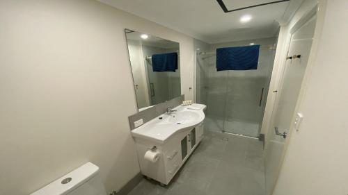 a white bathroom with a sink and a shower at Unit 54 Seafront Estate in Jurien Bay