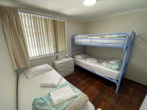 a bedroom with two bunk beds and a window at Tre Sorelle in Jurien Bay