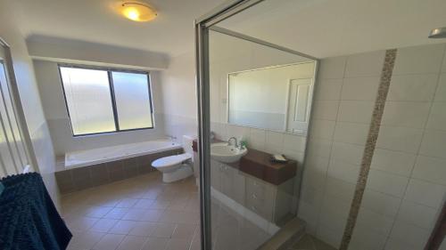 a bathroom with a shower and a toilet and a sink at Maniki Gardens in Jurien Bay