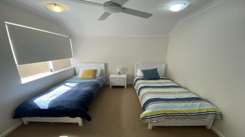 two twin beds in a room with a ceiling at The Beach House in Jurien Bay