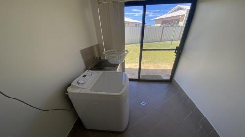 a washing machine in a room with a window at Maniki Gardens in Jurien Bay
