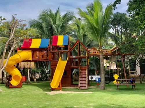 a playground with a slide and a play structure at Dolphin Bay Beach Resort in Sam Roi Yot