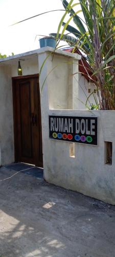 a sign on the side of a building at Rumah DOLE in Gili Islands