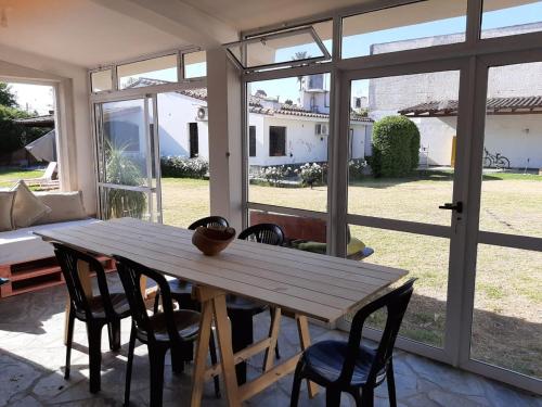 a wooden table and chairs in a room with windows at BenjaCha in Cerrillos