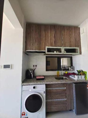 a kitchen with a washing machine and a sink at FOREST CITY@STARVIEW BAY&ATARAXIA PARK (SEAVIEW) in Gelang Patah
