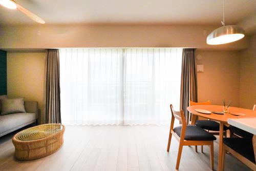 那覇市にあるBranchera Naha 1402のテーブルとソファと窓のあるリビングルーム