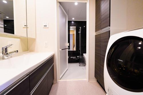 那覇市にあるBranchera Naha 1402のバスルーム(洗濯機、シンク、洗濯機、乾燥機付)