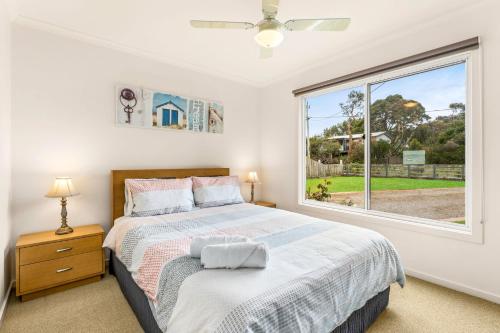 a bedroom with a bed and a large window at Views on Bayview in Cowes