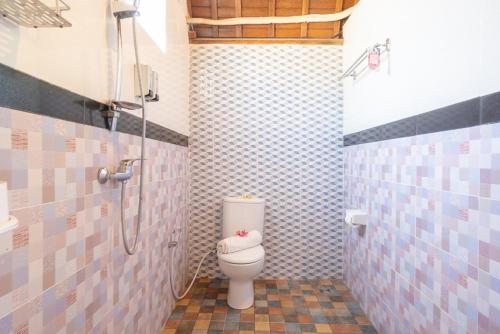 a bathroom with a toilet and a shower at Kukuh Penida Village by Bukit Vista in Nusa Penida