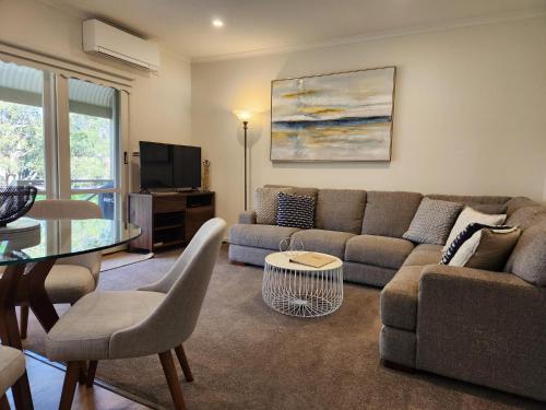 a living room with a couch and a table at McMillans of Metung Coastal Resort in Metung