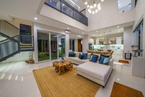 チャングーにあるVilla Ammanya - Modern 3-bedroom luxury villa in amazing location!のソファとテーブルのある広いリビングルーム