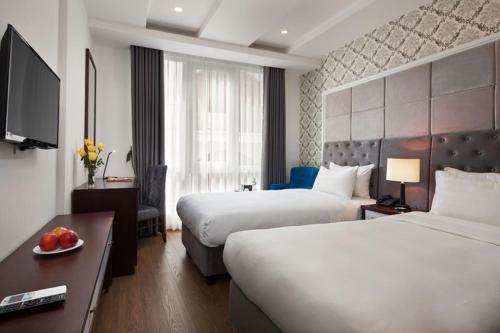 pokój hotelowy z 2 łóżkami i telewizorem w obiekcie Skyline Hanoi Hotel w mieście Hanoi