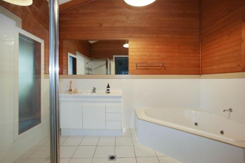 a bathroom with a tub and a sink at Bennett's Beach Cottage in Hawks Nest