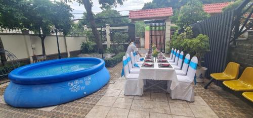 uma mesa com uma piscina insuflável azul ao lado de uma mesa com uma placa em Châu Gia Villa Vũng Tàu - Có chỗ đậu xe hơi em Vung Tau