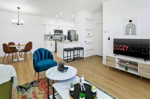a living room with a couch and a tv and a table at CozySuites Glendale by the stadium with pool 05 in Glendale