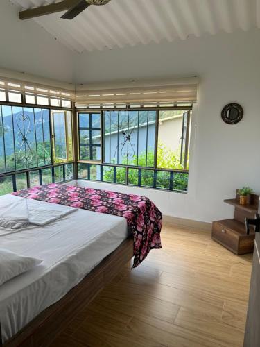 a bedroom with a large bed and large windows at Finca Don Matías in Melgar