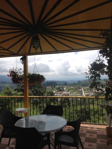 a patio with a table and chairs and an umbrella at Finca Cardonales in Salento