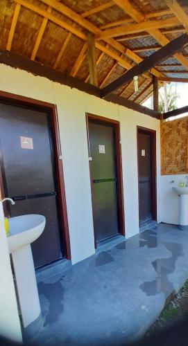 a room with three garage doors and a sink at Dream Catcher Nipas Siargao in General Luna