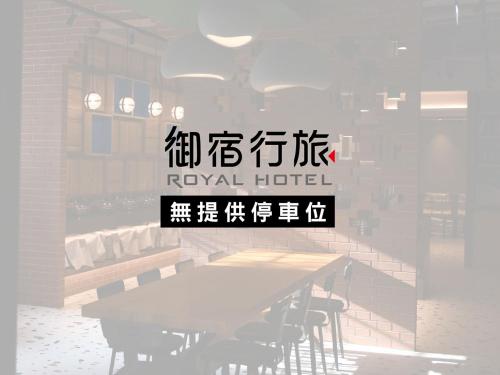 um sinal para um hotel real com uma mesa e cadeiras em Royal Group Hotel Xiong Zhong Branch em Kaohsiung
