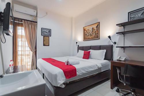 a bedroom with a bed and a bath tub and a sink at RedDoorz at Dago Asri 3 in Bandung