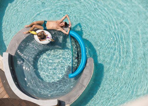 un uomo in una piscina su uno scivolo d'acqua di SKYVIEW Resort Phuket Patong Beach a Patong Beach