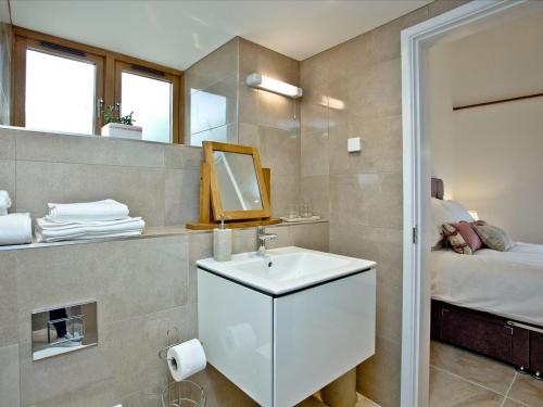 a bathroom with a sink and a mirror and a bed at The Stables - Bctstab in Upottery