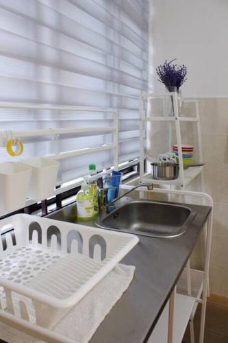 a kitchen counter with a sink and a window at The_Mozy Homestay in Tanjong Sepat