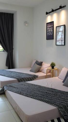 a room with two beds in a room at The_Mozy Homestay in Tanjong Sepat