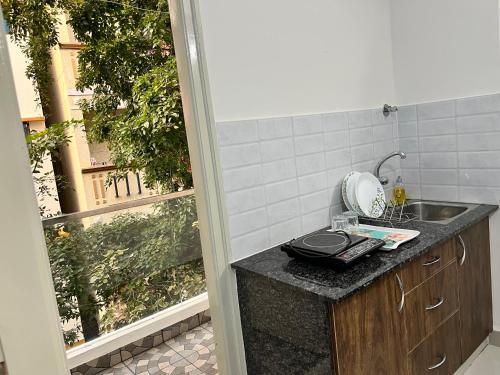 uma cozinha com um balcão com um lavatório e uma janela em StayhomeStays Prime em Bangalore
