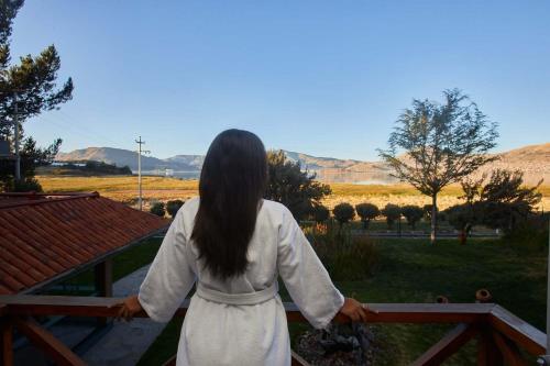 a woman standing on a fence looking out at a field at Casa Andina Premium Puno in Puno