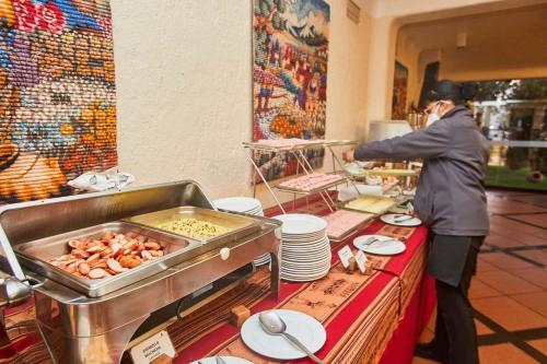 a woman talking on a cell phone at a table with food at Casa Andina Premium Puno in Puno