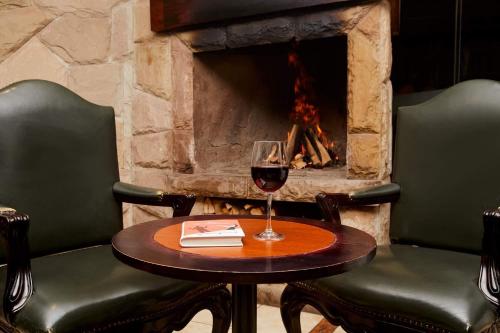 a glass of wine on a table in front of a fireplace at Casa Andina Premium Puno in Puno