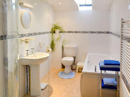 a bathroom with a sink and a toilet and a tub at The Stables in Alton Pancras