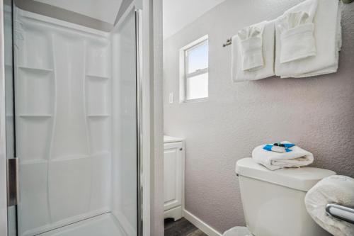 ein Bad mit einer Dusche und einem WC mit Handtüchern in der Unterkunft C6-Manatee in St Pete Beach