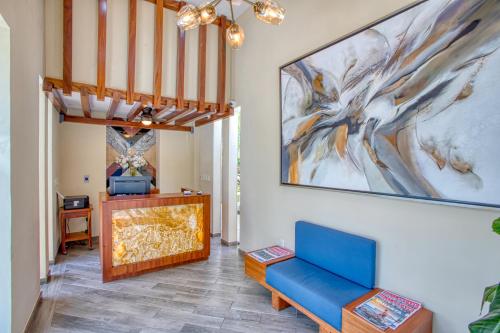 uma sala de estar com um sofá azul e uma pintura na parede em Casa Nicole Boutique Hotel em Puerto Vallarta