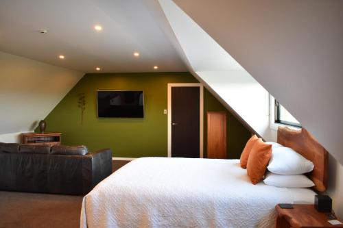 a bedroom with a white bed and a staircase at Atea Lodge in Coromandel Town