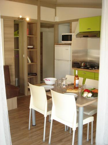 a kitchen and dining room with a table and chairs at Camping Frédéric Mistral in Castellane