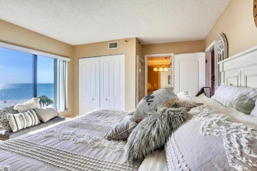 a bedroom with a bed with a view of the ocean at Caprice 401 in St. Pete Beach