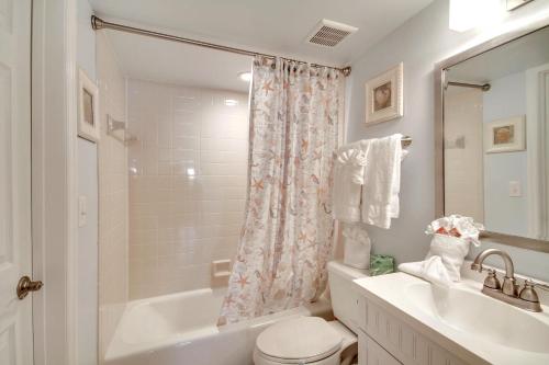 a bathroom with a sink and a toilet and a tub at Emerald Isle 101 in St. Pete Beach