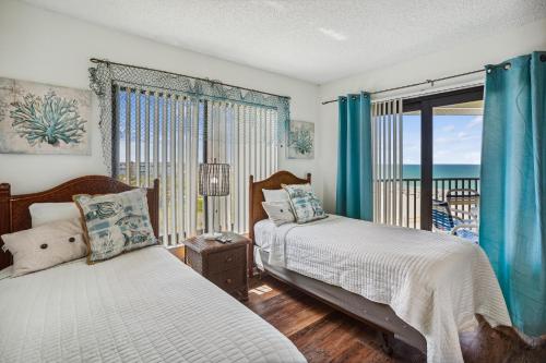 een slaapkamer met 2 bedden en een balkon bij Caprice 501 in St Pete Beach